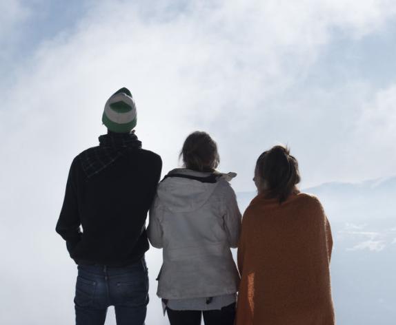 Three youth looking over a horizon